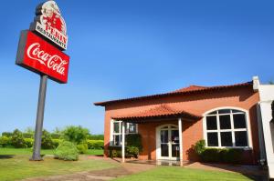 a building with a cocacola sign in front of it at Pekin Palace Hotel in Araçatuba