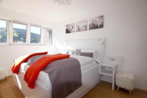 ein weißes Schlafzimmer mit einem großen Bett und Fenstern in der Unterkunft Apartment Bergjuwel in Sonnenalpe Nassfeld