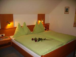 Un dormitorio con una cama verde con flores. en Gästehaus Eßl, en Mariapfarr