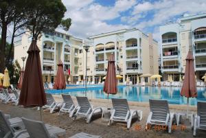 a group of chairs and umbrellas next to a swimming pool at Arbi's Pool View Apartment in Golem