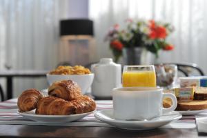 - une table avec des assiettes de pâtisseries et une tasse de café dans l'établissement inspiration by balladins Villefranche-de-Rouergue, à Villefranche-de-Rouergue