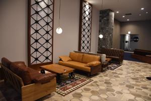 熊本市にあるHotel The Gate Kumamotoのソファ、椅子、テーブルのあるロビー