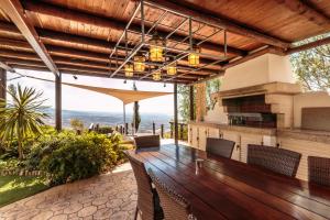 an outdoor patio with a wooden table and chairs at Oceania & Panorama Villas in Peyia