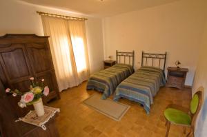 a room with two beds and a vase with flowers at Tenuta di Alberese in Alberese