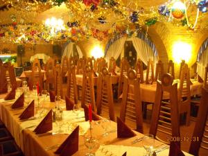 a dining room with tables and chairs and lights at Fodor Hotel in Gyula