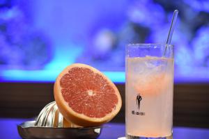 a slice of grapefruit next to a glass of drink at Hotel The Gate Kumamoto in Kumamoto