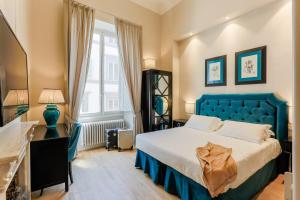 a bedroom with a blue bed and a window at Relais Tosinghi in Florence