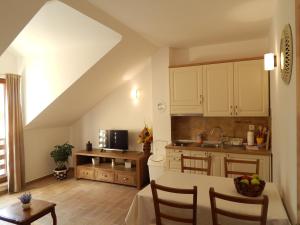 a kitchen with white cabinets and a table with chairs at Apartments Oltari in Sveti Juraj