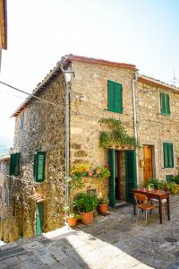 セッジャーノにあるantica abitazione con vista montagna Casa Normaの緑の襖とテーブルが備わる古い石造りの建物