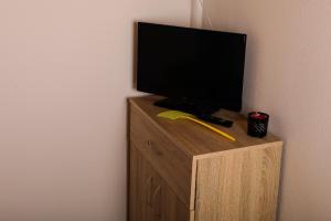 a flat screen tv sitting on top of a wooden cabinet at Ubytovanie Harmony House in Veľký Meder