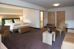 a hotel room with a bed and a living room at SPIEGLHOF apart in Kumhausen