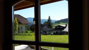 an open window with a view of a field and houses at Am Postgarten in Lam