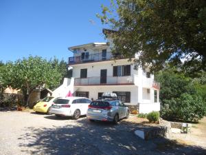 eine Gruppe von Autos, die vor einem Gebäude geparkt sind in der Unterkunft Apartments Vrša in Seline