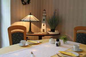 a table with a lamp and a lighthouse on a table at Gästehaus Niemerg in Warendorf