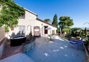 a patio with a tub and a table and chairs at Il Granaio in San Venanzo