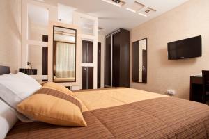 a bedroom with a large bed and a flat screen tv at Easy Room in Nizhny Novgorod