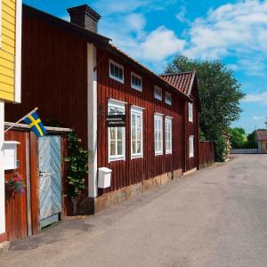 a red building with a flag on the side of it at Johanssons Gårdshotell i Roslagen in Östhammar