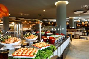 a buffet line with plates of food in a restaurant at Grand Palladium White Island Resort & Spa - All Inclusive in Playa d'en Bossa