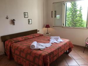 a bedroom with a bed with towels on it at Villa Nadia con splendida vista mare in Castellammare del Golfo