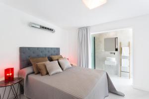 a white bedroom with a bed and a bathroom at VILLA CAN MASS Architect Country Villa in Sant Rafael de Sa Creu