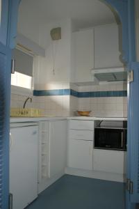 a white kitchen with white cabinets and a sink at Résidence les Grands Pins in Gréoux-les-Bains