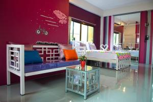a purple room with a couch and a table at Buorana in Chon Buri