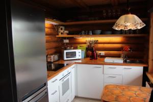 a kitchen with white cabinets and a stainless steel refrigerator at Akureyri Log Cottage in Akureyri