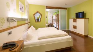Schlafzimmer mit einem Bett, einem Schreibtisch und einem TV in der Unterkunft Hotel Luisen Mühle in Mengeringhausen