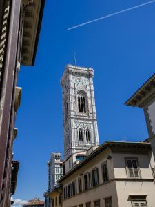 una torre del reloj alta en la parte superior de un edificio en Relais Tosinghi, en Florencia