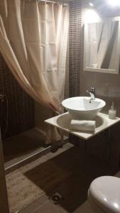 a bathroom with a sink and a shower and a toilet at Menehuna Heartmade Maison in Chorefto +11 photos