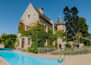um edifício com uma piscina em frente em Manoir de l'Abbaye em Seuilly