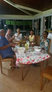 Un groupe de personnes assises autour d'une table dans l'établissement L'Oliveraie, à Saint-Joseph