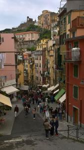 a group of people walking down a street with buildings at Casa De Batté in Riomaggiore