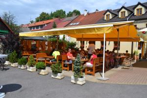 een groep mensen in een restaurant onder een paraplu bij Apartmány U Jezera Na Náměstí in Frymburk