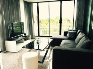 a living room with a couch and a tv and a table at Baan Paan Hua Hin in Hua Hin