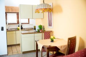 uma cozinha com uma mesa e uma pequena cozinha com um lavatório em Ferienapartments Schnibbe em Bad Lauterberg