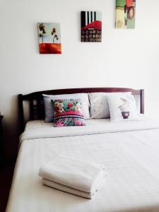 a white bed with two white towels on it at Baan Paan Hua Hin in Hua Hin