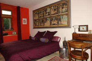 a bedroom with a bed and a desk and a painting at Domaine de Maleval in Mars
