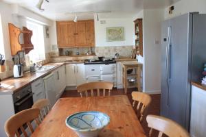 a kitchen with a wooden table and wooden chairs at Church Hill Farm in Monmouth