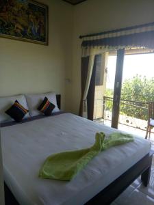 a bedroom with a white bed with a window at Bintang Homestay and Bungalow's in Amed