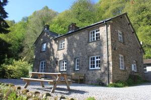 a stone building with a picnic table in front of it at Church Hill Farm in Monmouth