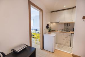 a kitchen with a white refrigerator and a table at LovelyStay - Charming Marques Flat in Lisbon