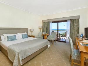 a bedroom with a bed and a desk and a balcony at Hotel Quinta do Lago in Quinta do Lago