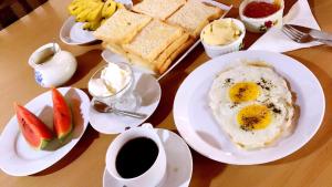 a table with plates of breakfast food and a cup of coffee at Eco Villa - Sinharaja in Deniyaya +50 photos