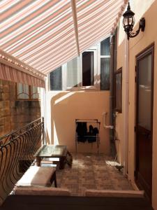 eine Terrasse mit Markise, einer Bank und einem Tisch in der Unterkunft Nocturne Family House in Paola