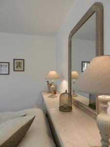 a bedroom with a mirror and a bed and a lamp at La Sembelie in Carsac-Aillac +7 photos