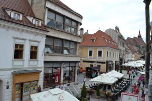 a city street with tables and umbrellas and buildings at Casa Republicii in Braşov