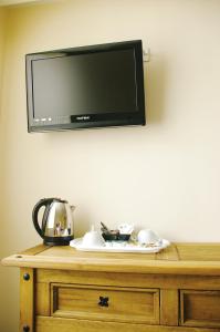 a flat screen tv on top of a wooden dresser at The Kings Head in Louth