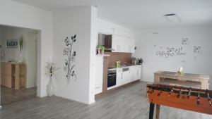 a kitchen with white cabinets and a table in a room at Moderne Neubau Ferienwohnung in Kassel