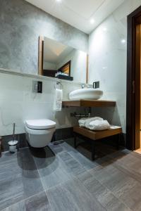 a bathroom with a toilet and a sink and a mirror at The Palms by Eagles in Takoradi